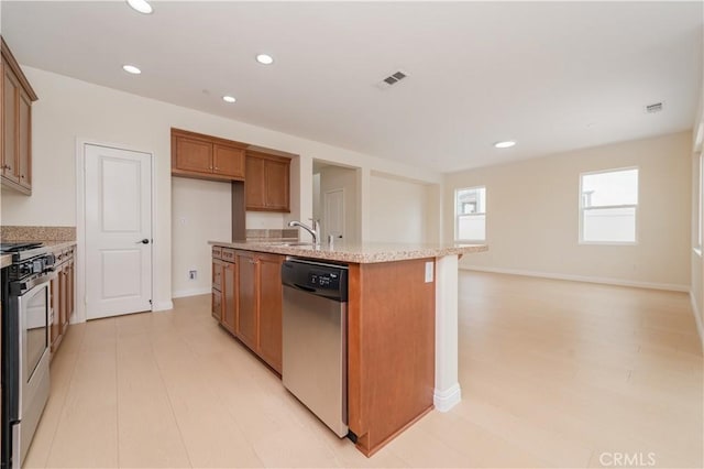 6611 Eucalyptus Ave, Chino, CA 91710 - kitchen featuring stainless steel appliances, brown cabinetry, a center island with sink, recessed lighting, and light stone counters