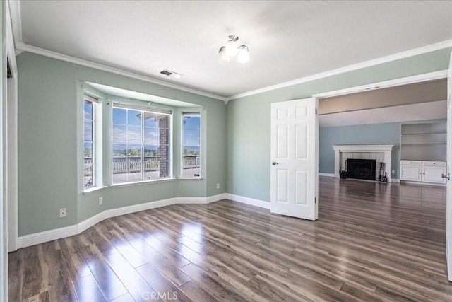 54326 Wildwood Springs Trl, North Fork, CA 93643 - unfurnished living room with dark wood-style flooring, crown molding, baseboards, and a tiled fireplace