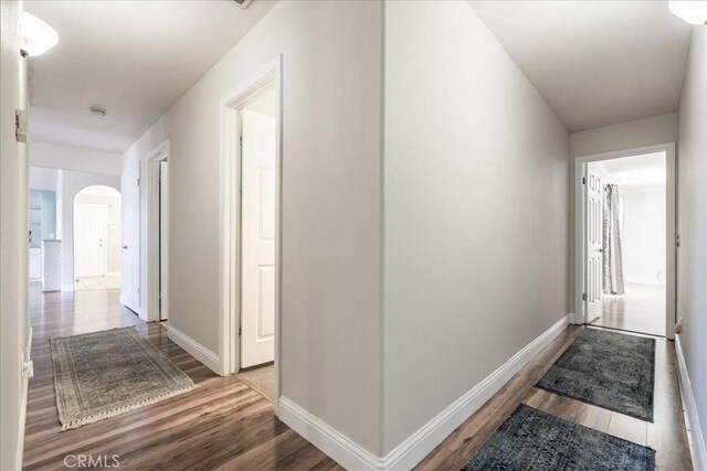 54326 Wildwood Springs Trl, North Fork, CA 93643 - corridor featuring arched walkways, wood finished floors, and baseboards