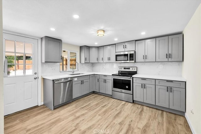 6064 Cahuilla Ave Unit 29, Palms, CA 92277 - kitchen featuring stainless steel appliances, gray cabinetry, light wood finished floors, tasteful backsplash, and recessed lighting
