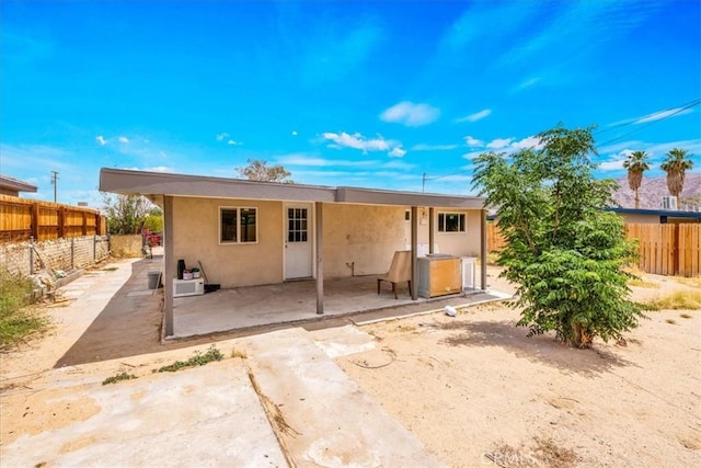 6064 Cahuilla Ave Unit 29, Palms, CA 92277 - rear view of house featuring a patio, a fenced backyard, and stucco siding