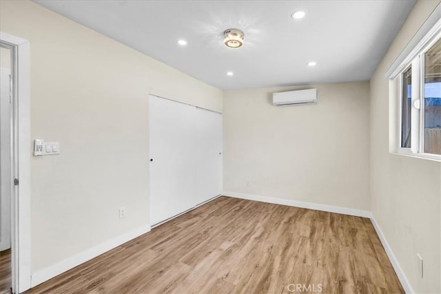 6064 Cahuilla Ave Unit 29, Palms, CA 92277 - unfurnished bedroom with a wall mounted air conditioner, wood finished floors, a closet, baseboards, and recessed lighting