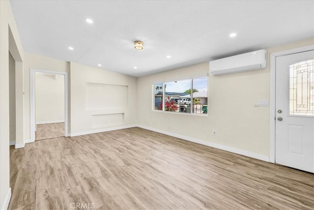 6064 Cahuilla Ave Unit 29, Palms, CA 92277 - unfurnished living room featuring a wall mounted AC, light wood-style floors, baseboards, and recessed lighting