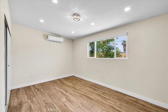 6064 Cahuilla Ave Unit 29, Palms, CA 92277 - below grade area with a wall unit AC, wood finished floors, baseboards, and recessed lighting