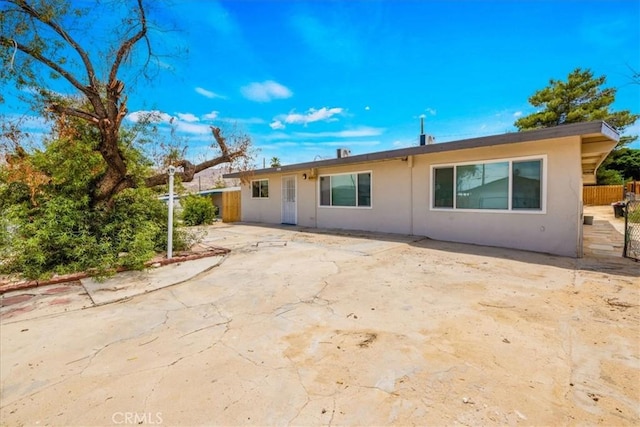 6064 Cahuilla Ave Unit 29, Palms, CA 92277 - rear view of house with stucco siding and a patio
