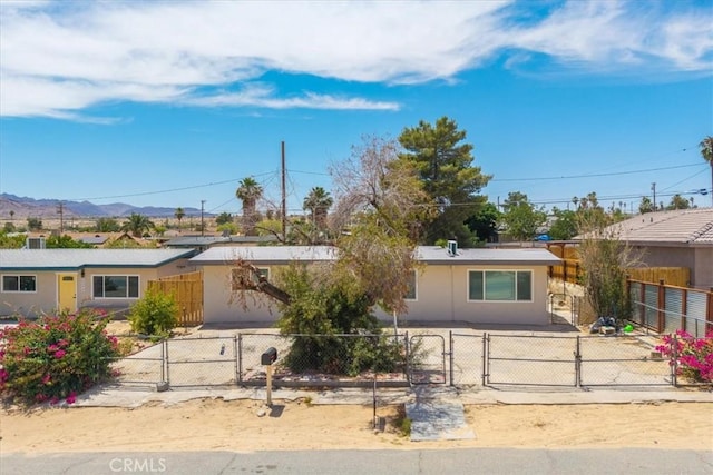 6064 Cahuilla Ave Unit 29, Palms, CA 92277 - ranch-style home featuring a gate, a mountain view, a fenced front yard, and stucco siding