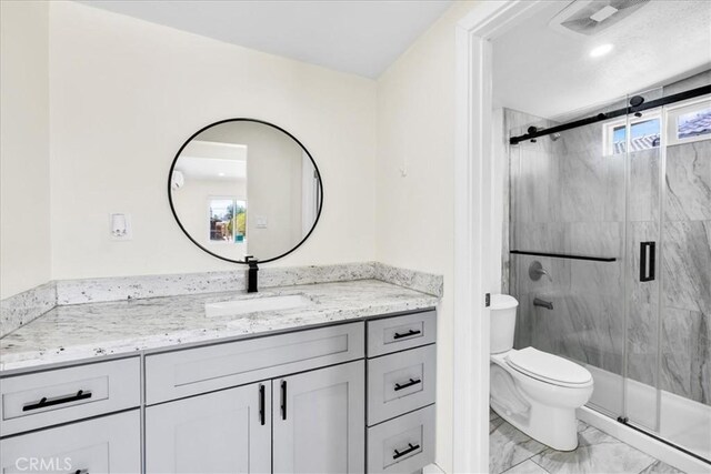 6064 Cahuilla Ave Unit 29, Palms, CA 92277 - bathroom with marble look tile flooring, vanity, a marble finish shower, and toilet