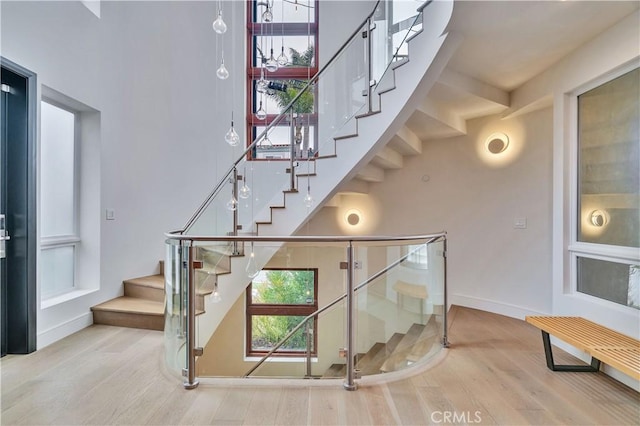 719 1st Pl, Hermosa Beach, CA 90254 - stairway featuring wood finished floors, a high ceiling, and baseboards