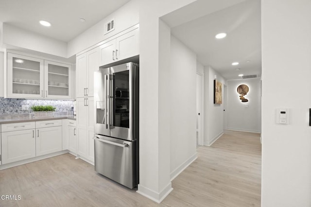 2850 Wagon Wheel Rd Unit 302, Oxnard, CA 93036 - kitchen with stainless steel refrigerator with ice dispenser, light wood-style flooring, white cabinetry, glass insert cabinets, and decorative backsplash