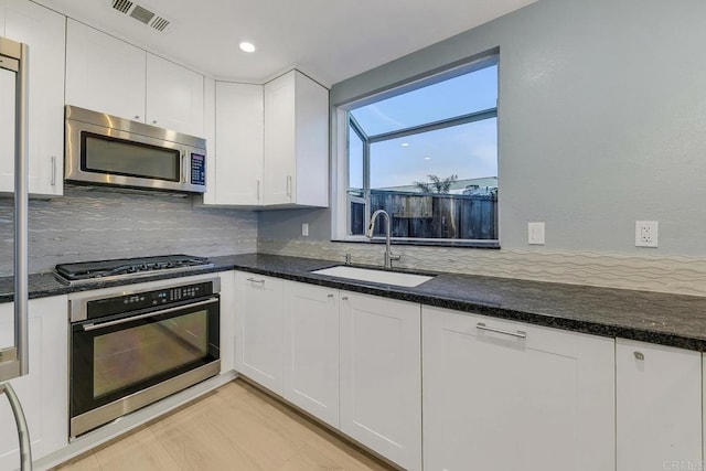 644 Grant St, Oceanside, CA 92054 - kitchen with stainless steel appliances, white cabinets, backsplash, dark stone counters, and recessed lighting