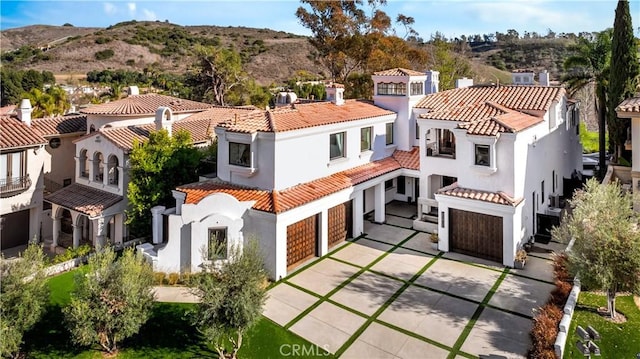 30402 Marbella, San Juan Capistrano, CA 92675 - back of property with an attached garage, stucco siding, concrete driveway, a tiled roof, and a mountain view