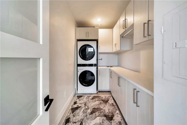 30402 Marbella, San Juan Capistrano, CA 92675 - washroom featuring stacked washer / drying machine, cabinet space, and light marble finish floors