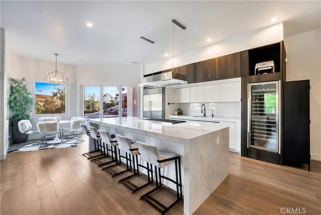 30402 Marbella, San Juan Capistrano, CA 92675 - kitchen featuring wine cooler, modern cabinets, wood finished floors, white cabinets, and recessed lighting