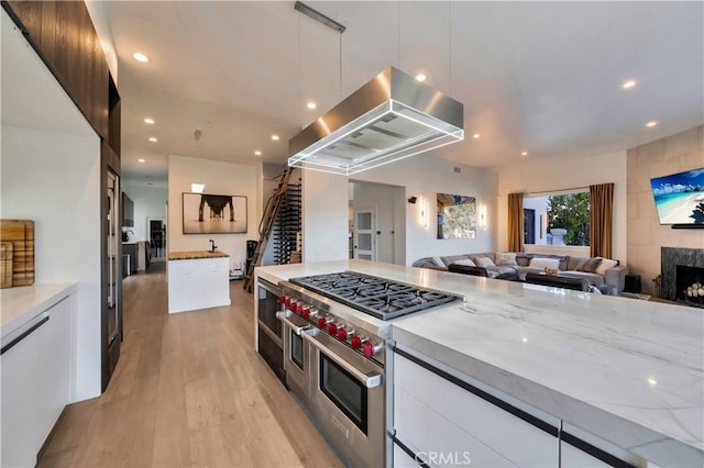30402 Marbella, San Juan Capistrano, CA 92675 - kitchen with exhaust hood, double oven range, white cabinetry, light wood finished floors, and recessed lighting