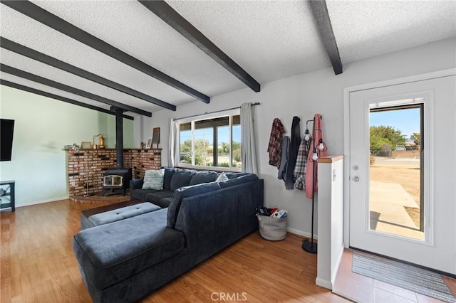 14650 Harding St, Hesperia, CA 92345 - living area featuring beamed ceiling, a textured ceiling, wood finished floors, a wood stove, and baseboards