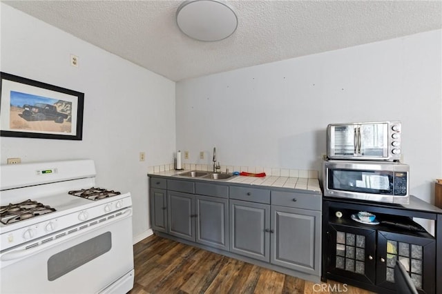 14650 Harding St, Hesperia, CA 92345 - kitchen featuring white range with gas cooktop, a sink, gray cabinets, stainless steel microwave, and a textured ceiling