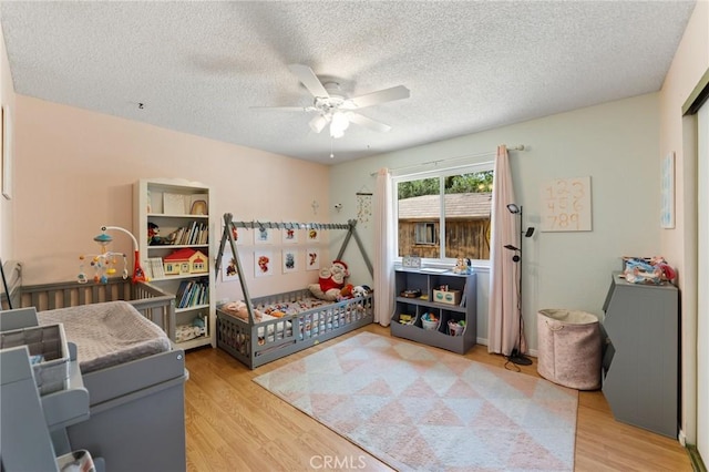 14650 Harding St, Hesperia, CA 92345 - bedroom featuring light wood-style flooring, a textured ceiling, and a ceiling fan