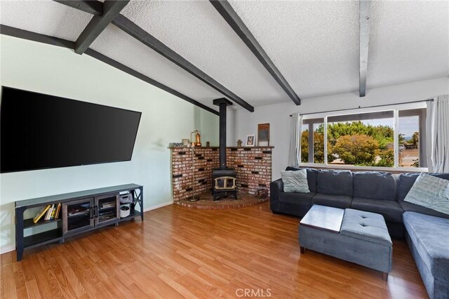14650 Harding St, Hesperia, CA 92345 - living room with a textured ceiling, a wood stove, light wood-type flooring, and baseboards