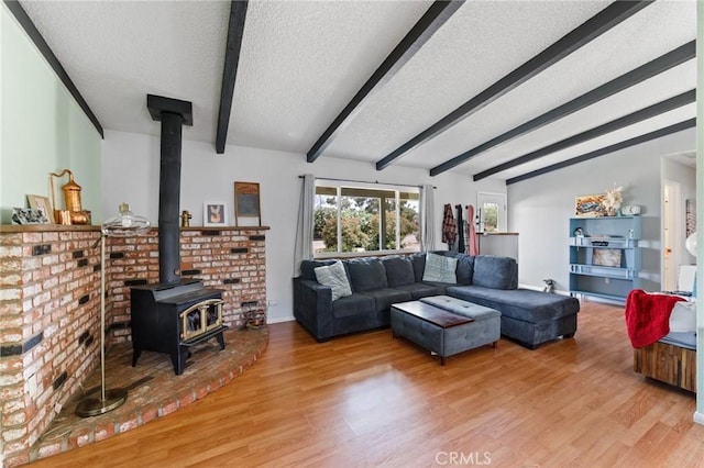 14650 Harding St, Hesperia, CA 92345 - living room with a textured ceiling, a wood stove, beamed ceiling, and light wood-type flooring