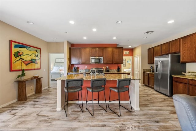 1316 Bannock St, Beaumont, CA 92223 - kitchen with stainless steel appliances, light wood finished floors, baseboards, recessed lighting, and a breakfast bar