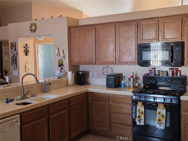 21224 Vidal Ct, Apple Valley, CA 92308 - kitchen with black appliances, a sink, brown cabinetry, tile countertops, and lofted ceiling