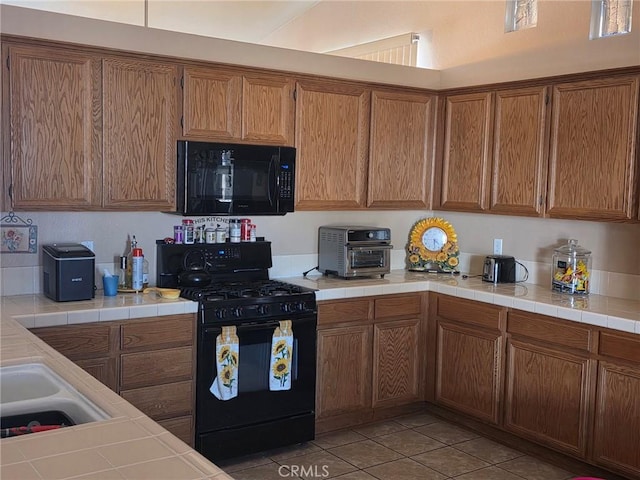 21224 Vidal Ct, Apple Valley, CA 92308 - kitchen with black appliances, brown cabinets, light tile patterned floors, tile counters, and a sink