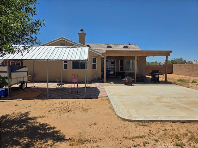 21224 Vidal Ct, Apple Valley, CA 92308 - rear view of house featuring a fire pit, a patio area, a chimney, and stucco siding