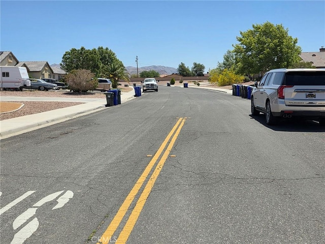 21224 Vidal Ct, Apple Valley, CA 92308 - view of asphalt road featuring curbs, sidewalks, a mountain view, and a residential view