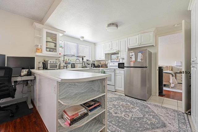 155 Rosebay Dr Unit 42, Encinitas, CA 92024 - kitchen with freestanding refrigerator, white electric range oven, open shelves, a textured ceiling, and glass insert cabinets