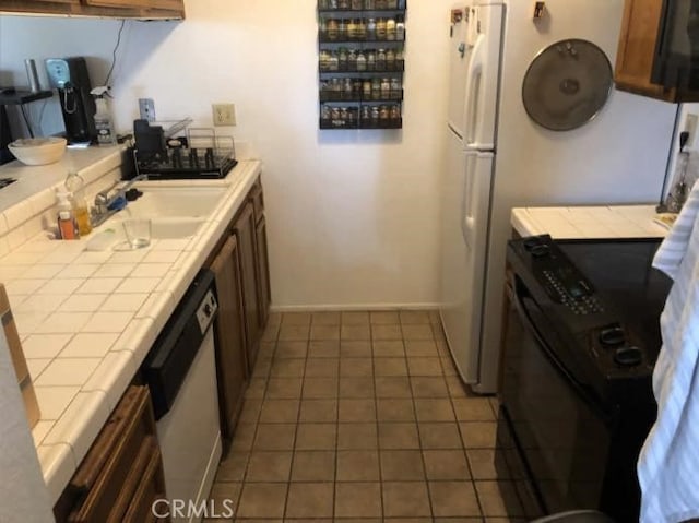 6188 Agee St Unit 230, San Diego, CA 92122 - kitchen with tile counters, white appliances, tile patterned floors, and baseboards