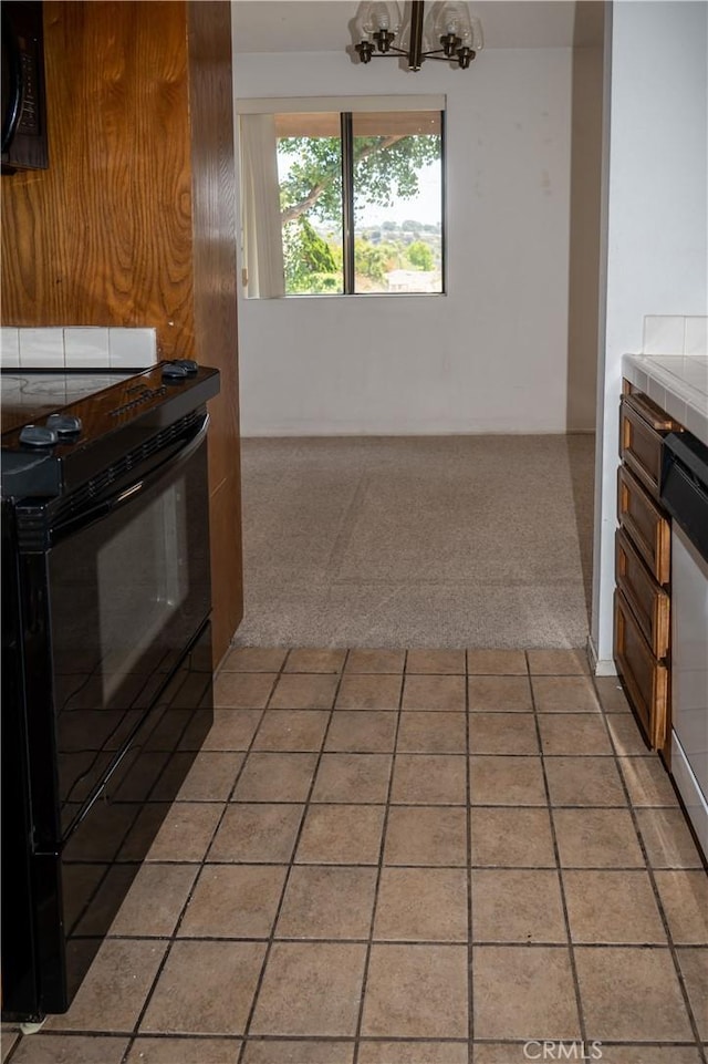 6188 Agee St Unit 230, San Diego, CA 92122 - kitchen featuring black appliances, tile counters, light colored carpet, and light tile patterned floors