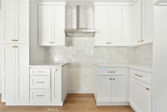 1027 E 10th St, Long Beach, CA 90813 - kitchen with wall chimney range hood, light wood finished floors, backsplash, white cabinetry, and light countertops