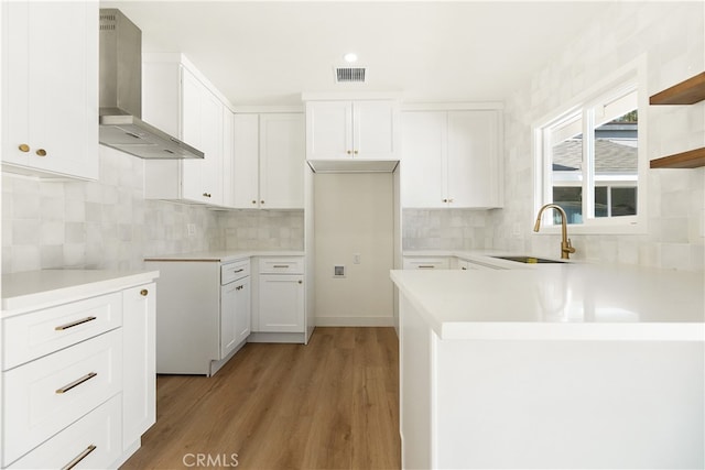1027 E 10th St, Long Beach, CA 90813 - kitchen featuring wall chimney exhaust hood, light wood-style flooring, tasteful backsplash, and white cabinets