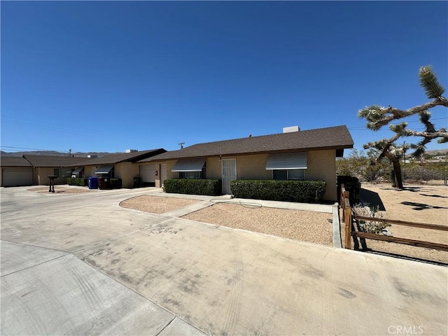 61947 Plaza Rd, Joshua Tree, CA 92252 - ranch-style house with a garage, stucco siding, and concrete driveway