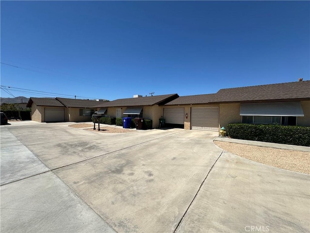 61947 Plaza Rd, Joshua Tree, CA 92252 - ranch-style house with stucco siding, an attached garage, and concrete driveway