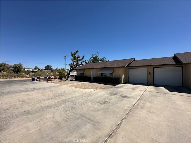61959 Plaza Rd, Joshua Tree, CA 92252 - view of front of home with concrete driveway, an attached garage, and stucco siding