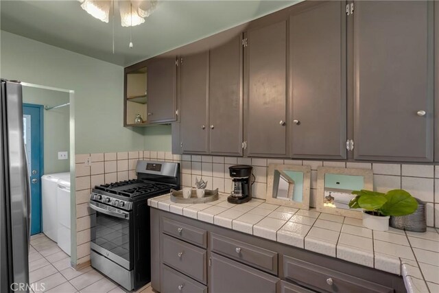 7860 La Fiesta Dr, Buena Park, CA 90620 - kitchen featuring stainless steel appliances, gray cabinetry, and washing machine and dryer