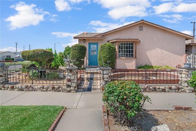 7860 La Fiesta Dr, Buena Park, CA 90620 - view of front of home featuring a fenced front yard, stucco siding, and a gate