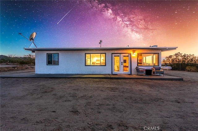 64952 Twentynine Palms Hwy, Joshua Tree, CA 92252 - back of property at dusk with stucco siding and a patio area