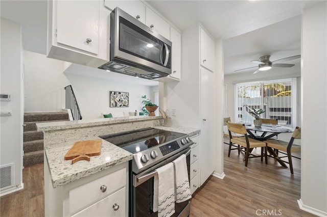 1634 Iowa St Unit B, Costa Mesa, CA 92626 - kitchen with stainless steel appliances, wood finished floors, white cabinetry, a ceiling fan, and light stone counters
