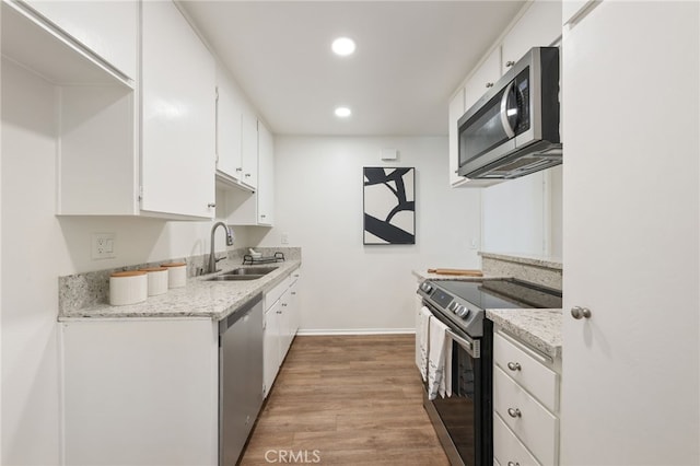 1634 Iowa St Unit B, Costa Mesa, CA 92626 - kitchen featuring stainless steel appliances, a sink, white cabinets, light wood-style floors, and recessed lighting