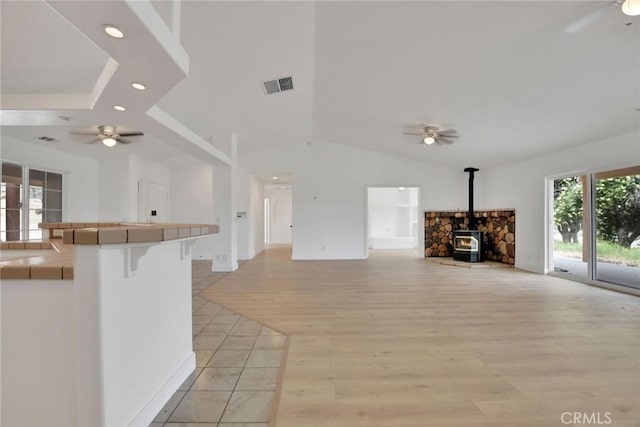 4426 Oil Well Rd, Phelan, CA 92371 - unfurnished living room with ceiling fan, a wood stove, light wood-type flooring, lofted ceiling, and recessed lighting