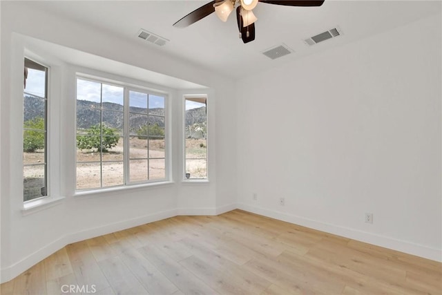 4426 Oil Well Rd, Phelan, CA 92371 - empty room featuring light wood-style flooring, a ceiling fan, baseboards, and a mountain view