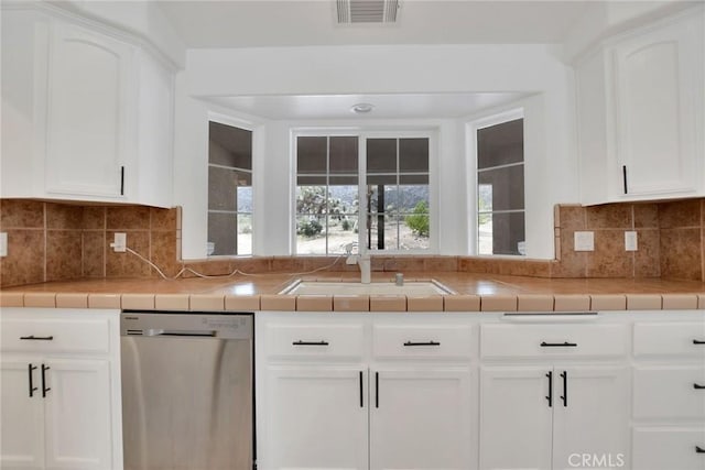 4426 Oil Well Rd, Phelan, CA 92371 - kitchen with stainless steel dishwasher, white cabinetry, a sink, decorative backsplash, and tile countertops