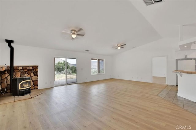 4426 Oil Well Rd, Phelan, CA 92371 - unfurnished living room featuring a ceiling fan, a wood stove, light wood-type flooring, and lofted ceiling