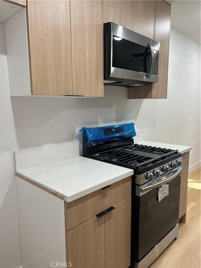 14805 Chase St Unit 224, Panorama City, CA 91402 - kitchen featuring stainless steel appliances, light brown cabinets, light wood-style flooring, light countertops, and modern cabinets
