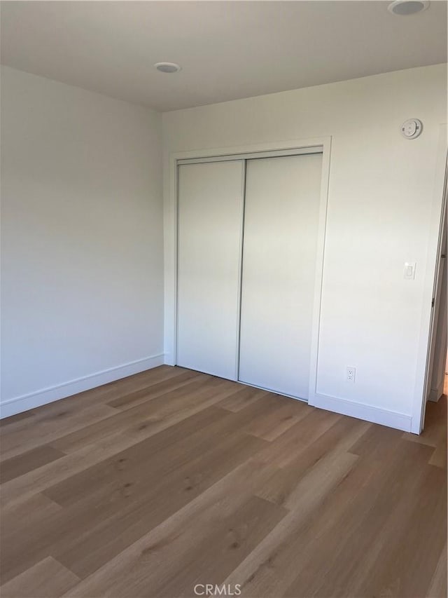 14805 Chase St Unit 224, Panorama City, CA 91402 - unfurnished bedroom featuring wood finished floors, a closet, and baseboards