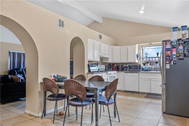 29039 Eveningside Dr, Castaic, CA 91384 - kitchen with stainless steel appliances, white cabinets, light tile patterned floors, a sink, and arched walkways