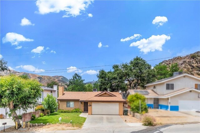 29039 Eveningside Dr, Castaic, CA 91384 - view of front of house with a garage, driveway, stucco siding, and a chimney