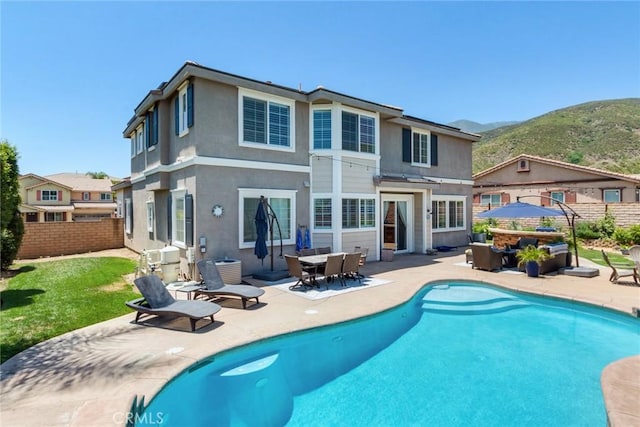 4765 Falconview Ct, Fontana, CA 92336 - back of house featuring a patio area, a mountain view, stucco siding, and an outdoor hangout area